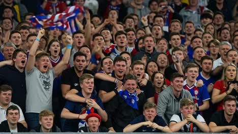 a thrilling atmosphere as passionate fans celebrate an exciting moment at a sporting event with energy and joyful expressions of team spirit