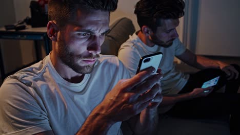 two men using smartphones at night