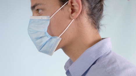 man putting on disposable surgical face mask, extreme closeup profile