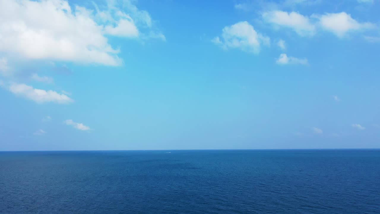 Deep ocean abstract background. Beautiful bright blue sky with fluffy white clouds above deep blue waters