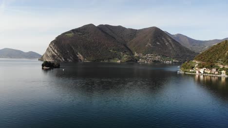 drone rotate over iseo lake revealing the coast in a beautiful autumn sunny day