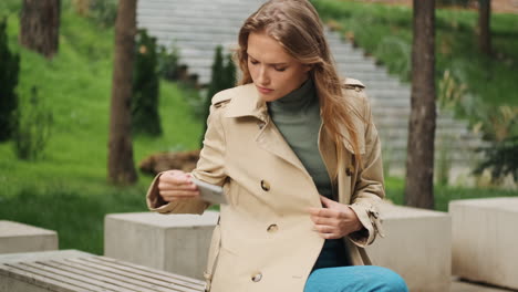 caucasian female student talking on the phone outdoors.