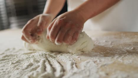 animation of hand of asian female baker preparing sourdough for bread