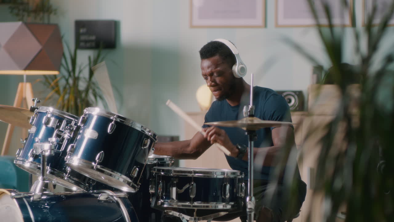 hombre tocando la batería en casa