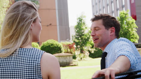 businessman talking to female colleague on break in park