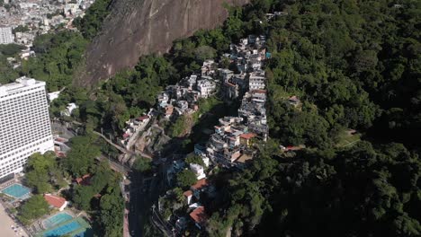 acercamiento aéreo e inclinación hacia abajo hacia la pequeña favela chacara de río de janeiro en las laderas de la montaña de los dos hermanos al lado del barrio de chabolas vidigal más grande