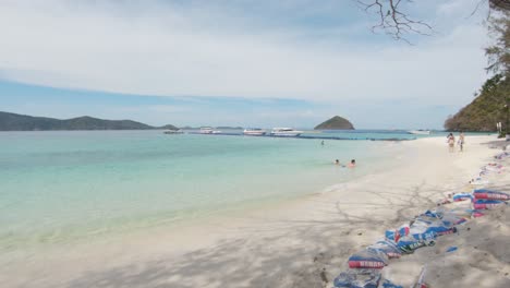 soft sandy beach bathed by emerald crystal clear water in koh hey , thailand - wide slide reveal shot