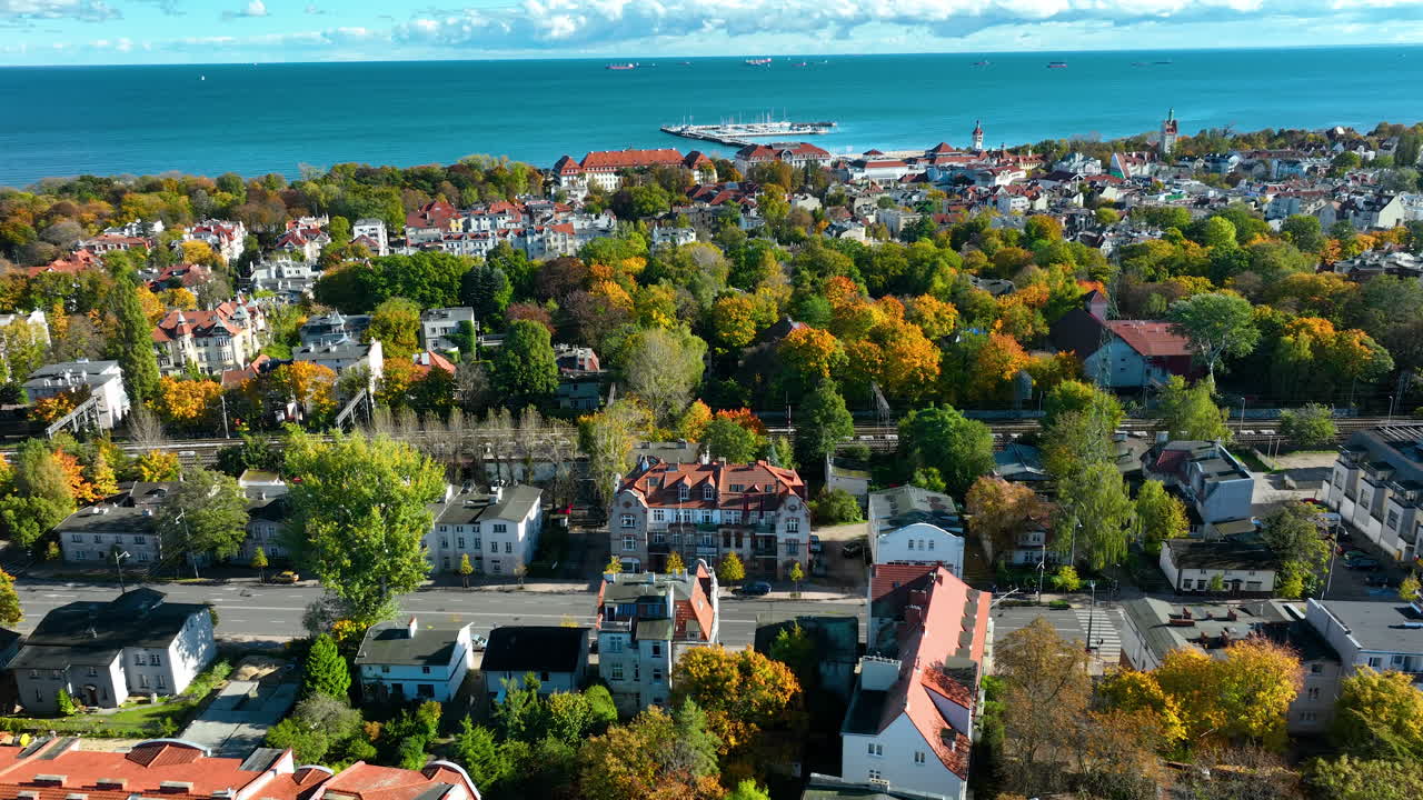 Aerial panorama of Sopot city with colorful autumn trees and Baltic Sea coastline in the background