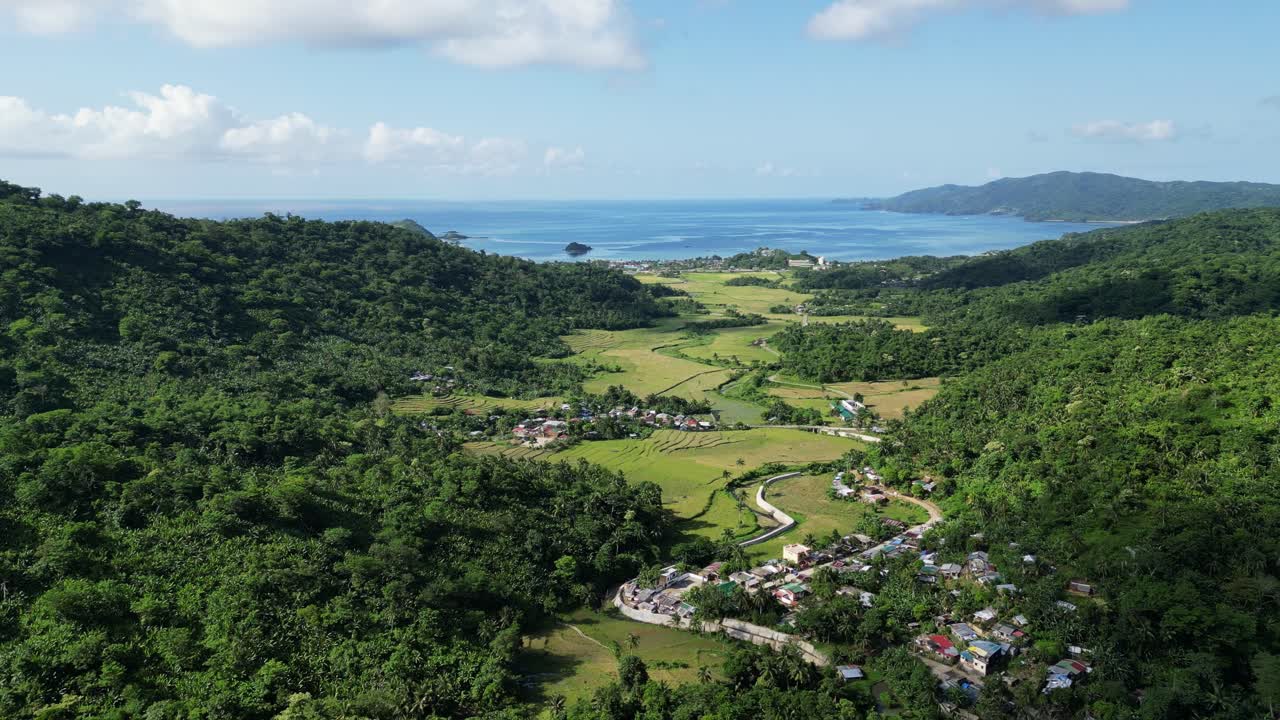 vista aérea de una ciudad rodeada de montañas verdes con vistas al mar azul en baras, catanduanes, filipinas
