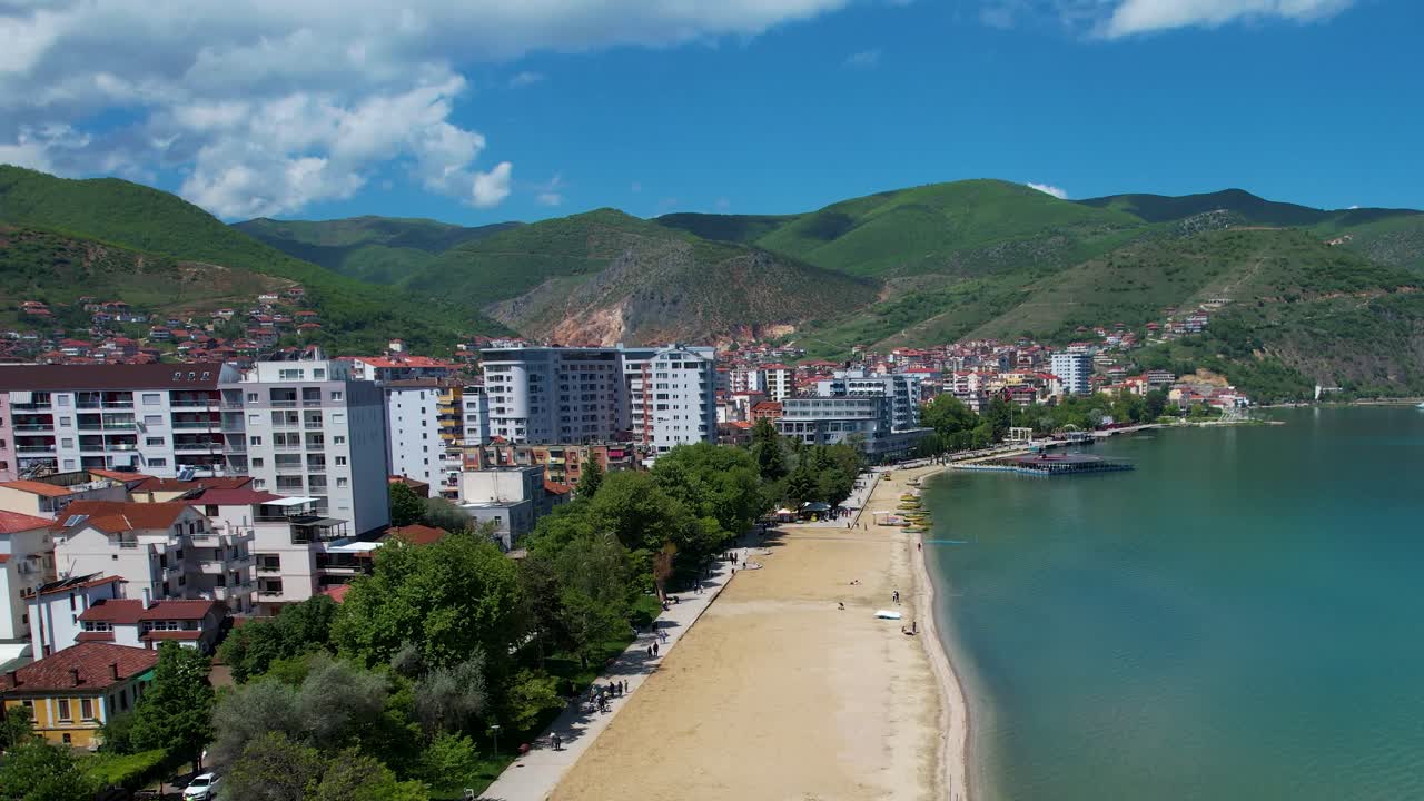 Pogradec'te, Ohri Gölü kıyısında, yazın güneşlenmek isteyenleri bekleyen plaja yakın oteller.