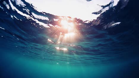 wave underwater, loop. sea surface underwater view. seamlessly loopable clip of the water surface with sun flare