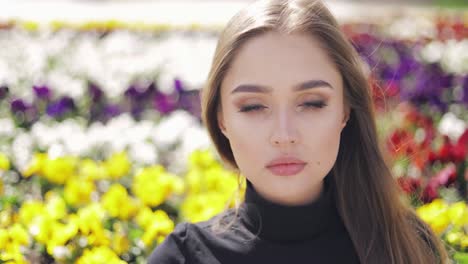 Schöne-Frau-Mit-Blauen-Augen-Und-Make-up-Posiert-Auf-Unscharfem-Hintergrund-Von-Bunten-Blumen