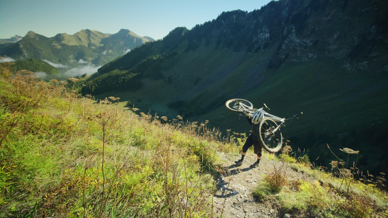 un ciclista de montaña lleva su bicicleta por un sendero alpino en otoño