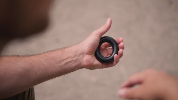 Man Exercises Grip, Silent Grip Strength Training In Progress, Slow Motion Of Hand Clenching Stress Ball At Park, Man Steadily Working On Forearm Strength With Textured Grip Device Outdoors