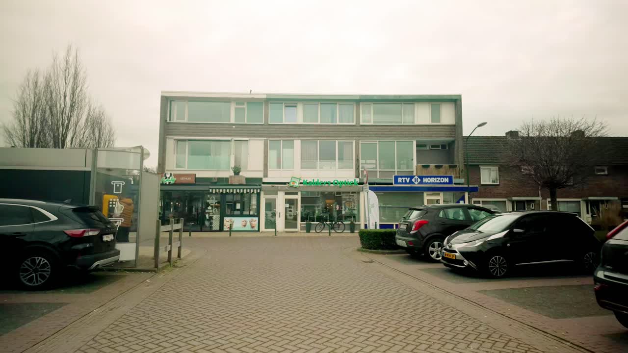Man Walking Past Shops on a Cloudy Day in the Netherlands