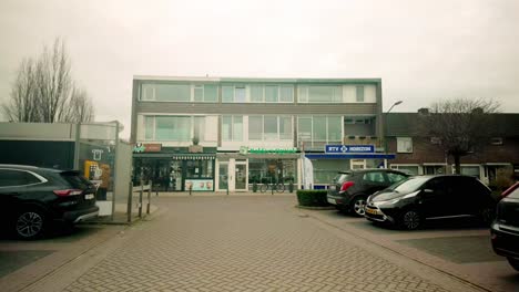 man walking past shops on a cloudy day in the netherlands