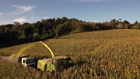 Tractor-Con-Remolque-Cosechando-Campos-De-Alfalfa-Durante-La-Puesta-De-Sol.