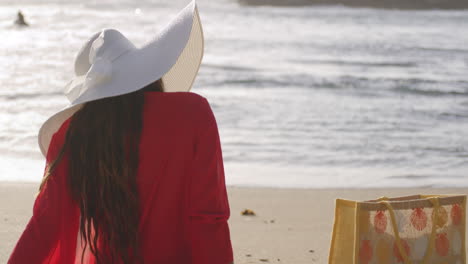 Happy-Laughing-Smiling-Face-of-Latin-Woman-Sitting-on-Beach-Seashore,-copy-space