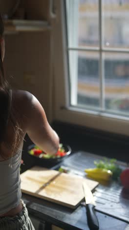 mujer preparando una ensalada en una cocina
