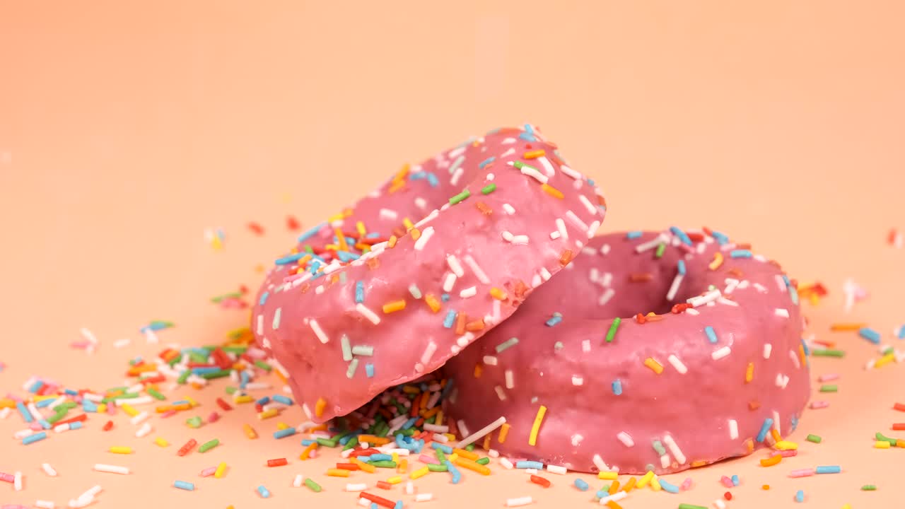 las virutas de colores que caen sobre dos rosquillas de fresa