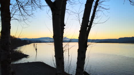 drone slowly panning to the right and revealing beautiful scenic view of a large lake during sunset