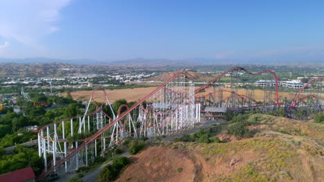 drone inclinándose sobre la montaña rusa en la montaña mágica de las seis banderas en california, estados unidos
