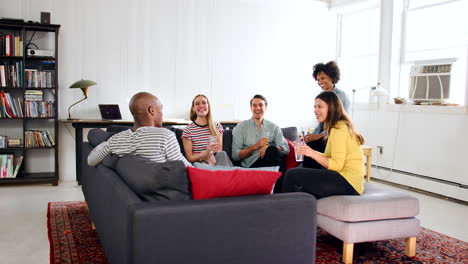 cinco amigos adultos se sientan hablando en un apartamento de un loft de nueva york.