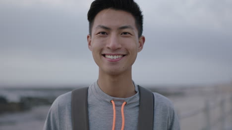 portrait of young asian man smiling cheerful confident on beach