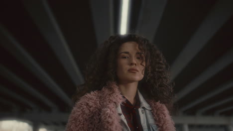 portrait of young pretty woman in stylish outfit under urban bridge