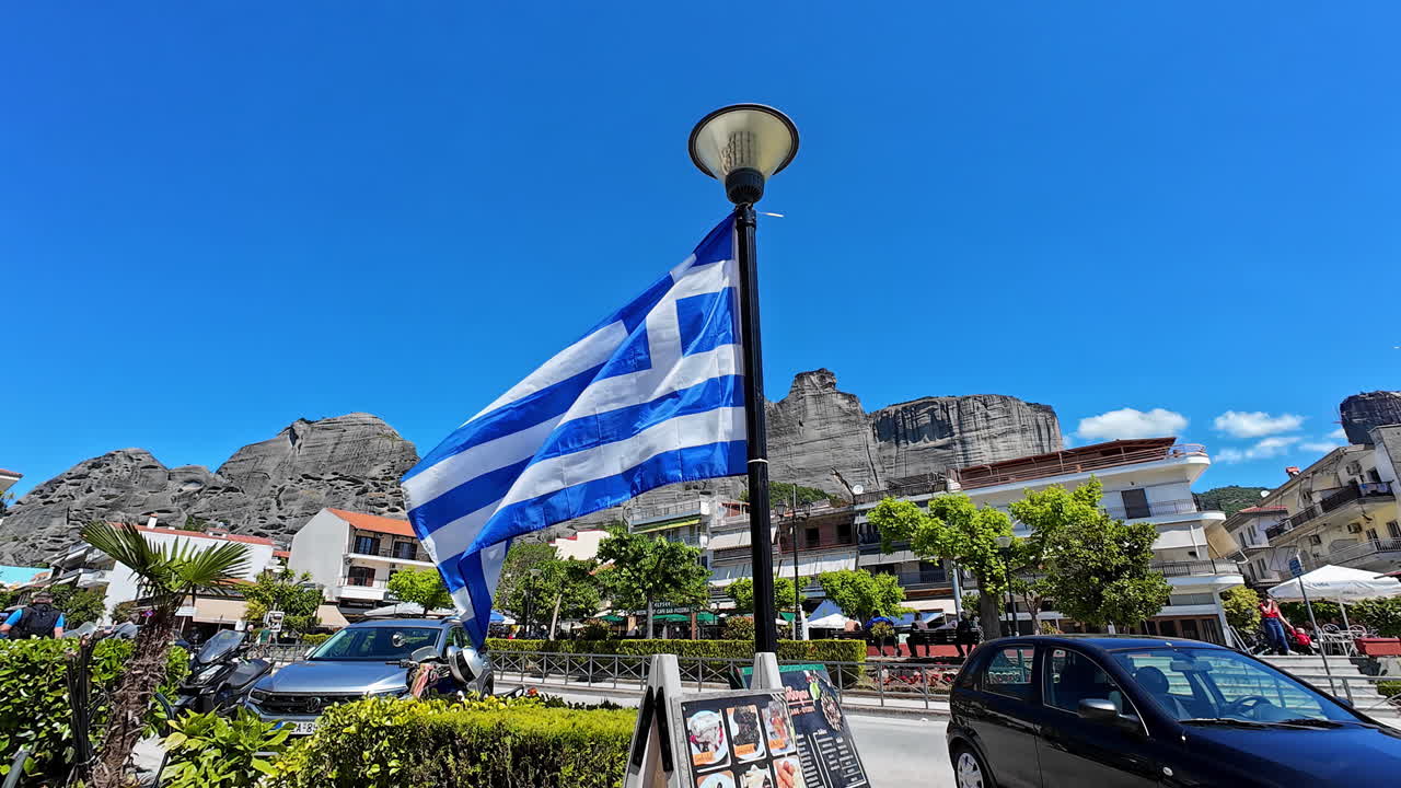 Greece flag waving in the city of Kastraki, Greece near Meteora, touristic place