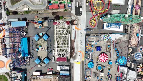 a slow descending cinematic drone shot over the colorful coney island amusement park in new york city