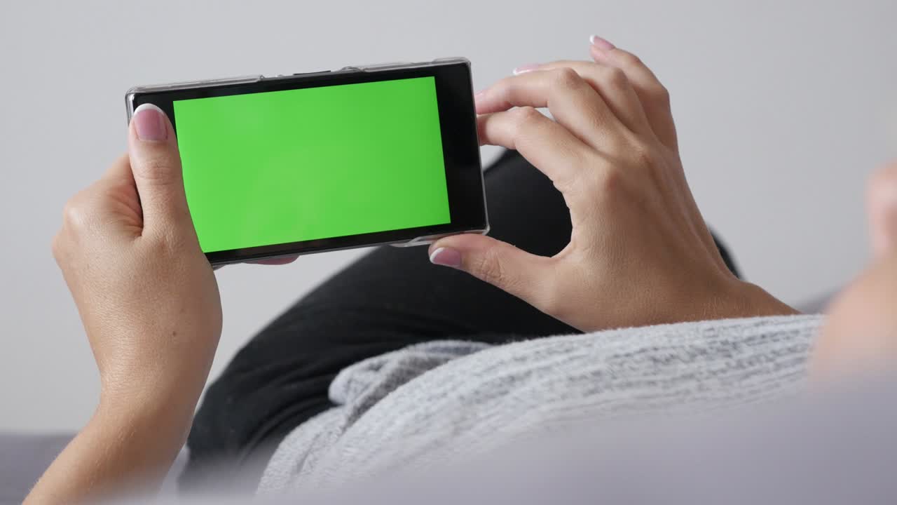 녹색 화면 디스플레이 스마트 폰 패닝과 함께 침대에서 휴식을 취하는 여성