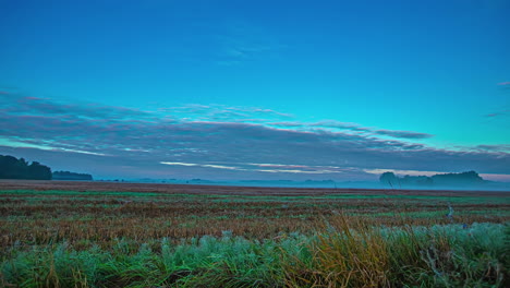 timelapse of clouds moving in blue sky over rural landscape