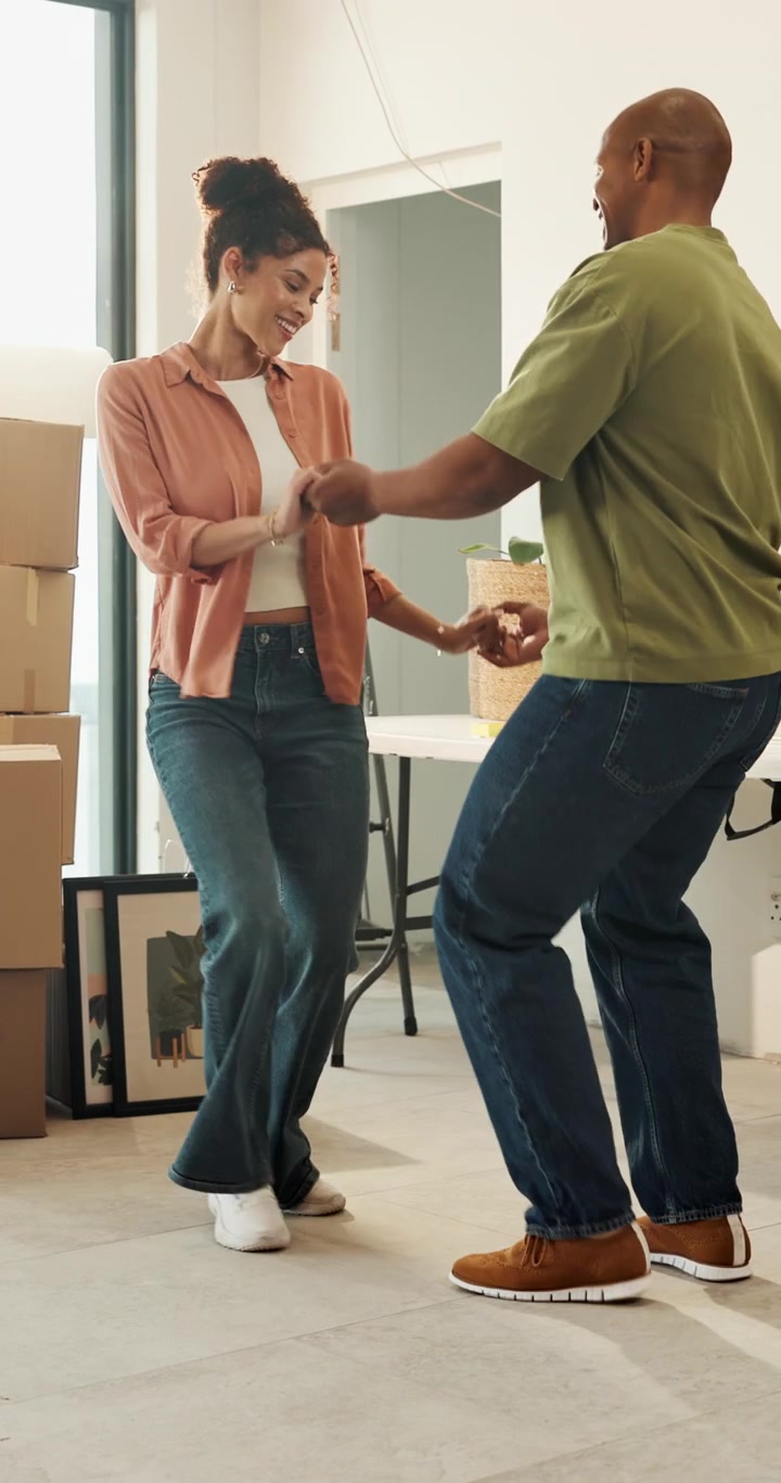 Happy Couple Dancing Together in Their New Home