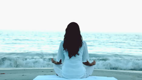 woman practicing yoga in front of the sea