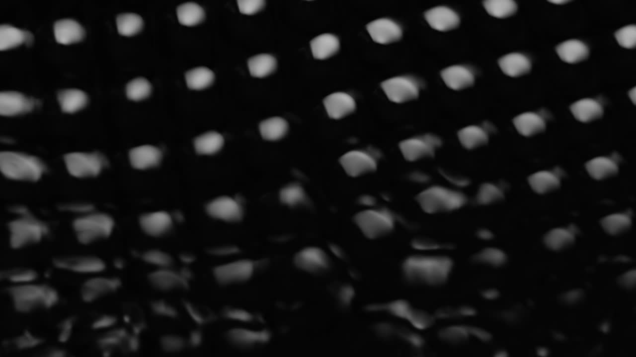 Splashes and drops on the surface of the liquid. Abstract Black Background Water vibration. 4K slow motion 100 fps, ProRes 422, 10 bit