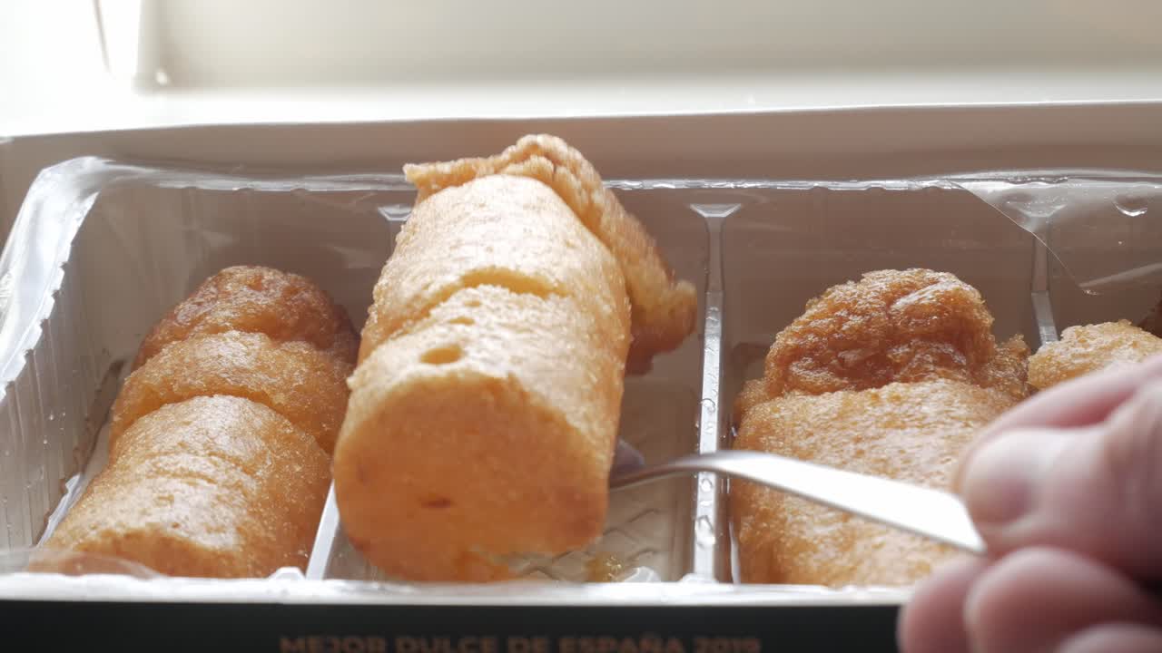 Golden syrupy chachepo sweets in plastic tray, traditional from Linares, Jaén, Spain