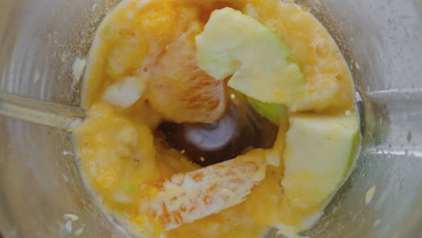 closeup preparing fruit puree in blender top view. ingredients blending in mixer