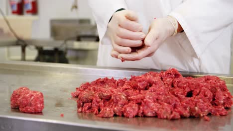 mid section of butcher preparing meat ball from minced meat