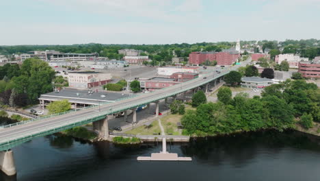 Aerial-Shot-Tracks-Along-Bridge-Towards-Bangor,-Maine-Offering-Spectacular-City-Views-with-Penobscot-River-in-the-Foreground