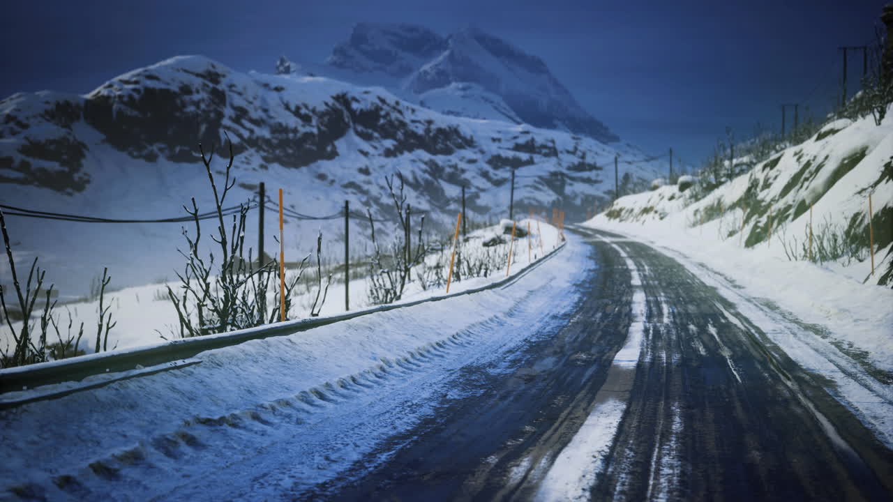 Snowy mountain road winding through a winter landscape with hills and trees