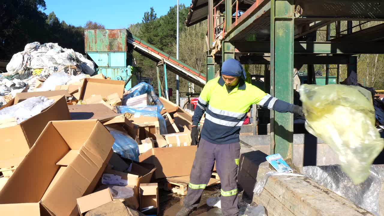 Recycling Plant with Worker Sorting Cardboard and Waste