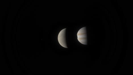a distant moon of the gas giant jupiter is eclipsed by another off camera moon before blocking out the gas giant itself
