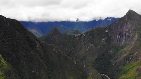 la famosa ciudadela inca de machu picchu en lo alto de una cresta en las montañas de los andes, 4k aérea