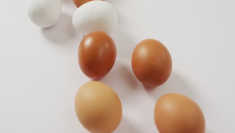 Close-up-view-of-brown-and-white-eggs-on-white-surface