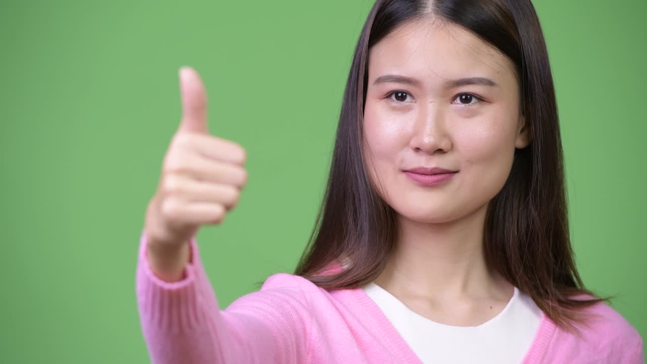 젊은 아름다운 아시아 여성이 엄지손가락을 올리고