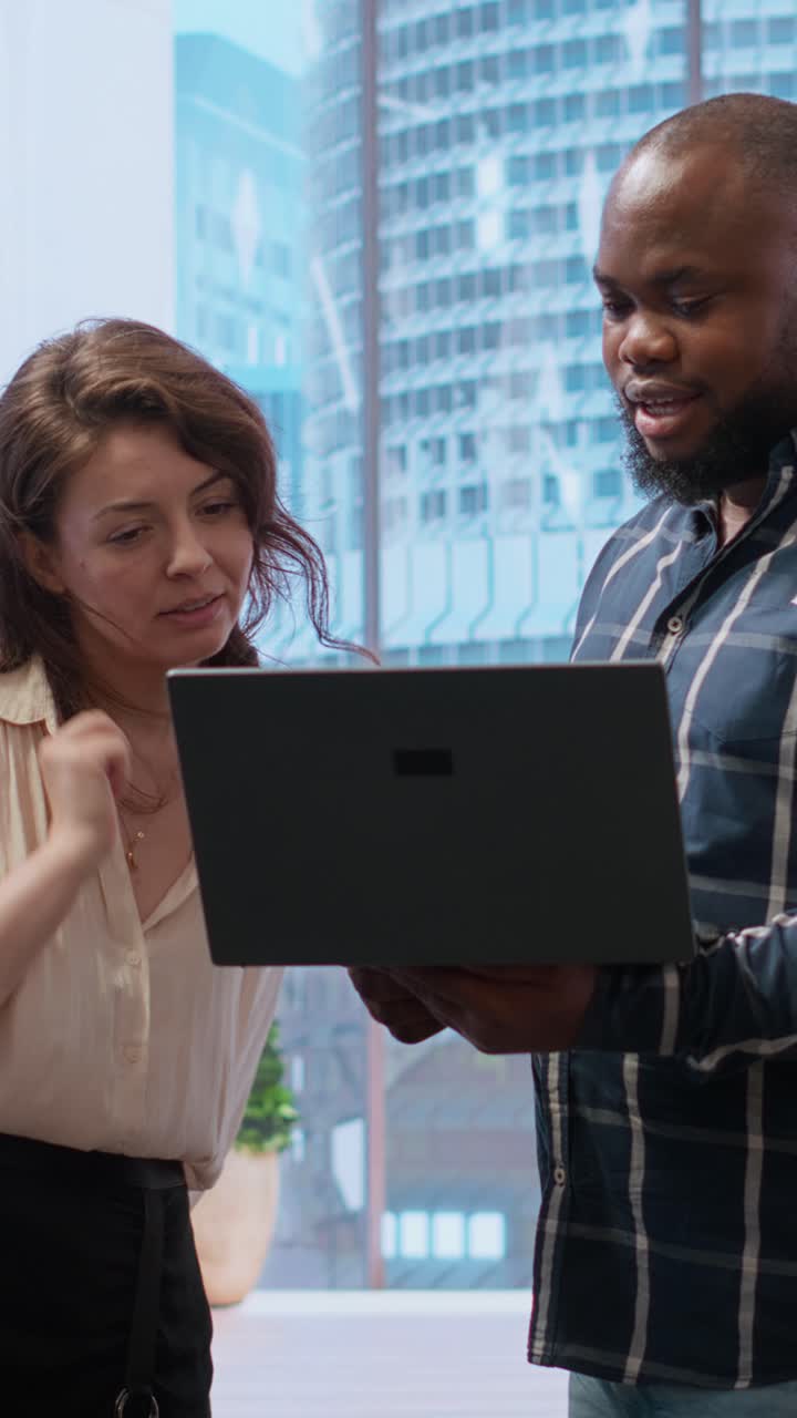 Diverse Business Colleagues Discussing Project on Laptop in Modern Office