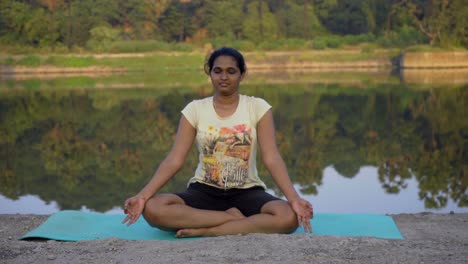 indian girl meditating doing meditation by the lake side mumbai india thane