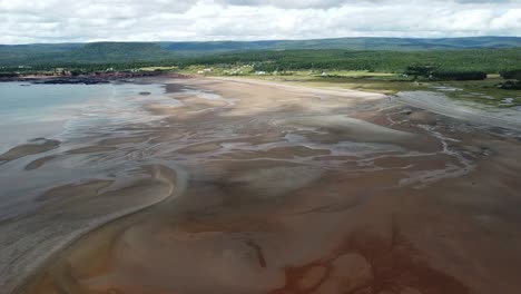 tiro alto de drones de la playa junto al agua, nuevo brunswick que muestra la costa y los afluentes del agua