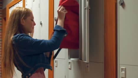 student gathering her school books from a locker